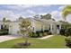 Charming single-story home featuring lush landscaping, manicured lawn, and a paved walkway to the front entrance at 11053 Barnsley Dr, Venice, FL 34293