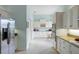A well-lit kitchen with stainless steel appliances, white cabinetry, and granite countertops at 11053 Barnsley Dr, Venice, FL 34293