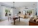 Bright living room featuring dining area, neutral color palette, tile flooring, and sliding doors to the patio at 11053 Barnsley Dr, Venice, FL 34293