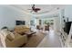 Light-filled living room boasts neutral tones, tile floors, ceiling fan, and sliding glass doors to lanai at 11053 Barnsley Dr, Venice, FL 34293