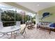 Relaxing screened lanai with comfortable seating and view of tropical greenery at 11053 Barnsley Dr, Venice, FL 34293