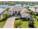 Stunning single-story home with a tile roof, lush landscaping, and a serene waterfront view at 1374 Brenner Park Dr, Venice, FL 34292