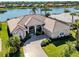 Beautiful home with a tile roof, lush landscaping, and a tranquil waterfront location at 1374 Brenner Park Dr, Venice, FL 34292