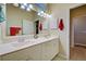 Bright bathroom featuring double sinks, a large mirror, and updated lighting fixtures in a well-lit space at 1655 Lancashire Dr # 1655, Venice, FL 34293