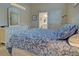 Comfortable bedroom with a decorative bedspread, complementary dresser and an adjoining bathroom doorway at 1655 Lancashire Dr # 1655, Venice, FL 34293