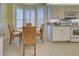 Bright kitchen features a breakfast nook with wicker chairs and views from plantation-shuttered windows at 1655 Lancashire Dr # 1655, Venice, FL 34293
