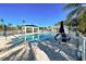 Scenic pool area with clear water, shaded seating, and palm trees offering a tranquil retreat at 1655 Lancashire Dr # 1655, Venice, FL 34293
