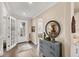 Inviting entryway boasts natural light, a stylish console table with a round mirror, and wood-look tile flooring at 18987 Formosa St, Venice, FL 34293