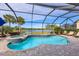 Screened-in pool and spa offer picturesque lake views and lush landscaping at 18987 Formosa St, Venice, FL 34293