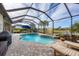 Pool area featuring a screened enclosure, in-ground pool and spa, and beautiful lake views at 18987 Formosa St, Venice, FL 34293