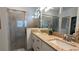 Modern bathroom with a double sink vanity, granite countertop, decorative fixtures, and glass shower at 19716 Fishhawk Trl, Venice, FL 34293