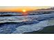 Beautiful beach scene with waves crashing on the shore at sunset, offering a serene coastal experience at 19716 Fishhawk Trl, Venice, FL 34293