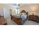 Spacious bedroom with a ceiling fan, a large window, and a decorative wooden bed frame at 19716 Fishhawk Trl, Venice, FL 34293
