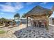 Backyard with a tiki bar, swings, brick pavers, and tropical landscaping provides the perfect outdoor retreat at 1985 Fairview Dr, Englewood, FL 34223