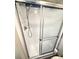 Shower with sliding glass doors, mounted shower head, and a small shelving unit at 28 Castaway Ct, North Port, FL 34287