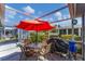 Enclosed patio has table with chairs, a grill, and a red umbrella with a view to the community at 3300 Loveland Blvd # 1504, Punta Gorda, FL 33980