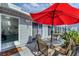 Enclosed patio featuring a table and chairs, a red umbrella, and a view into the home's living space at 3300 Loveland Blvd # 1504, Punta Gorda, FL 33980