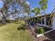 Expansive backyard with lush lawn, patio, and mature trees provides a serene outdoor retreat at 335 Englewood Isles Pkwy # 55, Englewood, FL 34223