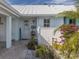 Charming front entrance with white picket fence and lush tropical foliage create inviting curb appeal at 335 Englewood Isles Pkwy # 55, Englewood, FL 34223