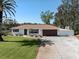 Charming single-story home with a well-manicured lawn, mature palm trees, and a driveway leading to an attached garage at 809 Garland Ave, Nokomis, FL 34275