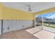 Living room with bright yellow walls, tile floor and sliding glass door to outdoors at 833 White Cap Cir # 8, Venice, FL 34285