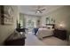 Cozy bedroom with soft green walls, large window, ceiling fan, and comfortable bedding at 900 Paisley Ct # 1, Venice, FL 34293