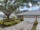 Well-maintained home featuring a large, well-manicured yard and a white two-car garage at 900 Paisley Ct # 1, Venice, FL 34293