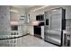 Bright kitchen features stainless steel appliances, white cabinetry, and a breakfast nook with a glass-top table at 900 Paisley Ct # 1, Venice, FL 34293