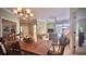 Open-concept living room and dining area with chandelier, ceiling fan, and sliding glass doors to patio at 900 Paisley Ct # 1, Venice, FL 34293