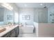 Bright bathroom with a luxurious soaking tub, glass shower and marble patterned wall at 11571 Gleaming Ter, Venice, FL 34293