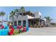 Outdoor seating in a lively commercial district with palm trees and colorful chairs at 11571 Gleaming Ter, Venice, FL 34293