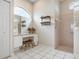 Bright bathroom featuring a vanity with a makeup area, shelves, and a shower with glass block accents at 1282 Reserve Dr, Venice, FL 34285