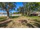 Large backyard featuring mature trees, a well-maintained lawn, and a white privacy fence at 237 Southampton Ln # 275, Venice, FL 34293