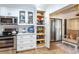 Well-organized kitchen with white cabinets, including a pull-out pantry, and stainless steel appliances at 237 Southampton Ln # 275, Venice, FL 34293