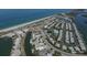 Scenic aerial view of a coastal community with a beach, canal, condos, and a roundabout at 2737 Cottage Ln, North Port, FL 34286