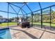 Screened-in lanai with a hot tub overlooking a fenced yard and shed at 2737 Cottage Ln, North Port, FL 34286