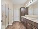 Bright bathroom features double vanity, wood-look tile, and walk-in glass shower at 2737 Cottage Ln, North Port, FL 34286