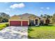 A beautiful single-Gathering home with a well-manicured lawn, a wide driveway, and a spacious two-car garage at 2737 Cottage Ln, North Port, FL 34286