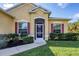 Inviting front entrance with a screened-in porch, decorative shutters, and manicured landscaping at 2737 Cottage Ln, North Port, FL 34286