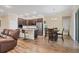 Open-concept kitchen and dining area with stainless steel appliances, dark wood cabinets and wood-look tile flooring at 2737 Cottage Ln, North Port, FL 34286