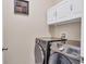 Well-lit laundry room features modern washer and dryer and cabinet storage at 2737 Cottage Ln, North Port, FL 34286