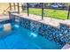 Beautiful pool with water feature and tiled accents in screened lanai at 2737 Cottage Ln, North Port, FL 34286