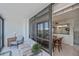 Relaxing screened-in balcony with comfortable seating next to the dining room and kitchen with views of the city at 627 Alhambra Rd # 601, Venice, FL 34285