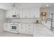 Bright kitchen features white cabinets, countertops, microwave and electric range at 627 Alhambra Rd # 601, Venice, FL 34285
