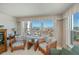 Living room chairs with ocean views from a large window in a well-lit sitting area of the condo at 627 Alhambra Rd # 601, Venice, FL 34285