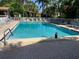 A serene community pool view surrounded by lounge chairs and tropical landscaping at 634 Bird Bay E Dr # 103, Venice, FL 34285