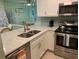 Renovated kitchen features white cabinets, stainless steel appliances, and stone countertops at 634 Bird Bay E Dr # 103, Venice, FL 34285