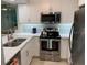 Renovated kitchen features white cabinets, stainless steel appliances, and stone countertops at 634 Bird Bay E Dr # 103, Venice, FL 34285