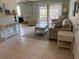 Bright living room featuring neutral-toned furnishings, tile floors, and sliding glass doors at 634 Bird Bay E Dr # 103, Venice, FL 34285