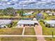 Aerial view of a charming single-story home with canal access, brick driveway and adjacent screened in pool at 6627 Marius Rd, North Port, FL 34287